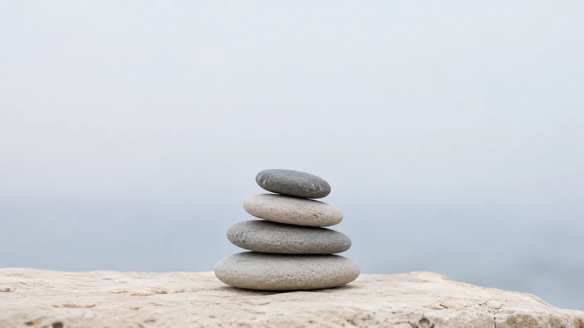 A stack of balanced river stones with clear space above